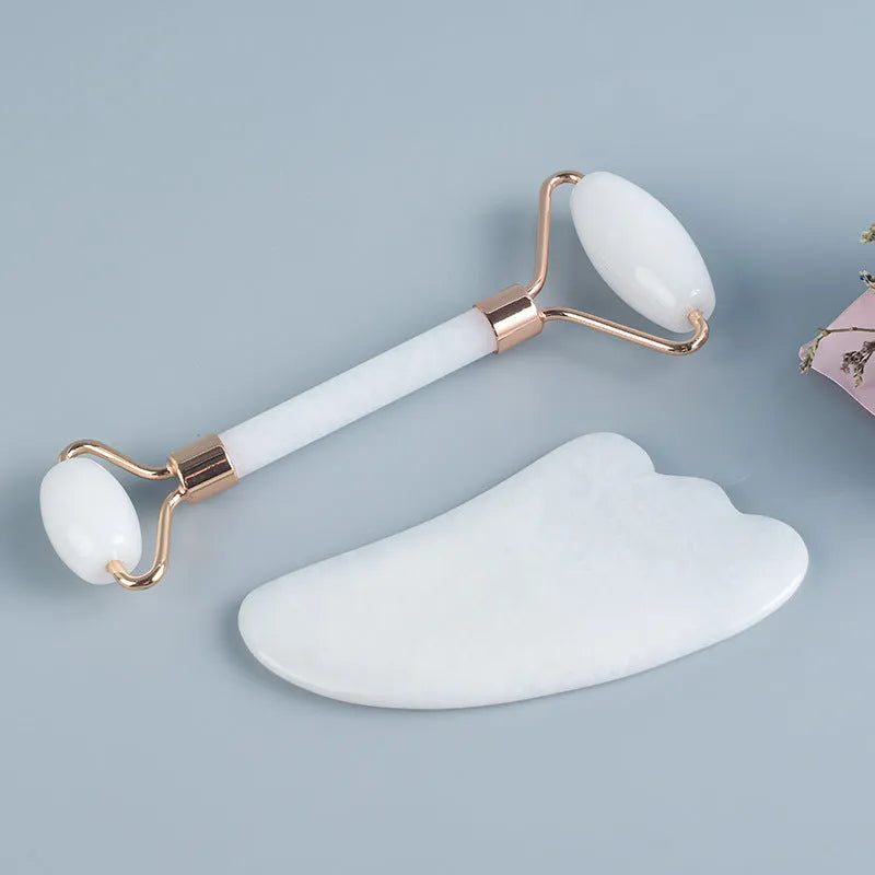 White jade facial roller with double-headed claw design and matching scraping board for manual massage
