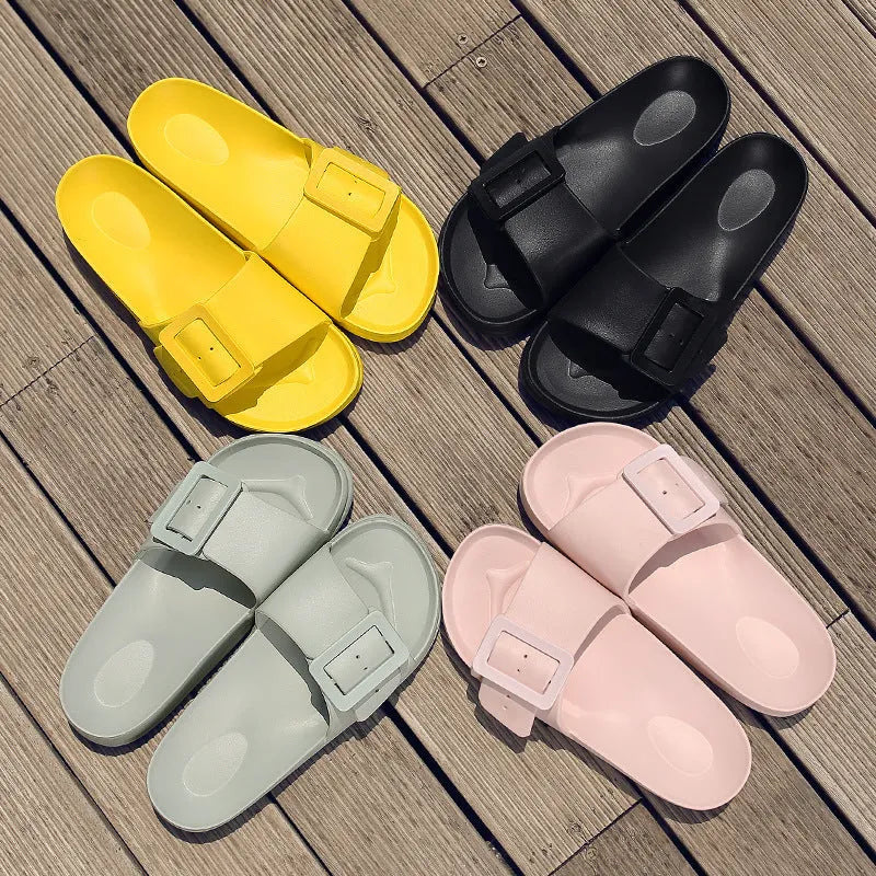 Women's grey blue buckle flip-flop slippers on a light background, showing adjustable strap and cushioned sole.