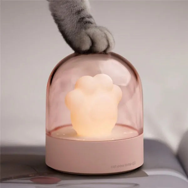 Grey cat paw shaped night light with USB charging port and control button showing soft illumination