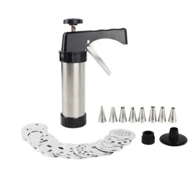 Stainless steel biscuit press gun with assorted cookie moulds and piping nozzles on a baking tray.