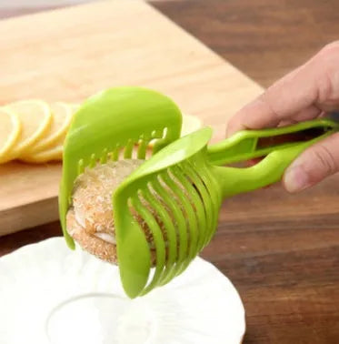 Green plastic fruit and vegetable cutting holder with slicing grid, measuring 18.5 cm.