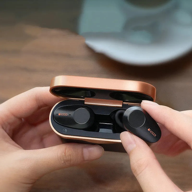 Black wireless Bluetooth earbuds with ANC and a wireless charging stand.
