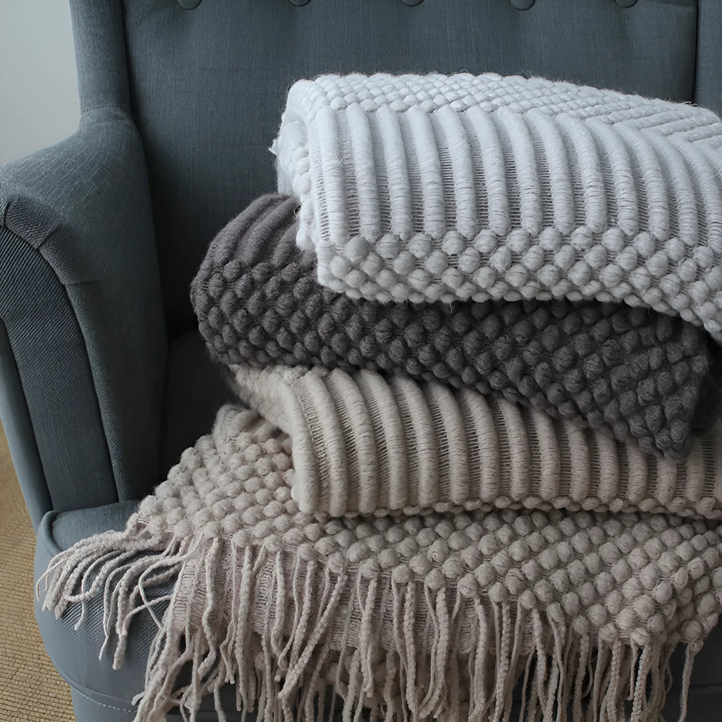 Small grey polyester nap blanket folded to show its texture and size.
