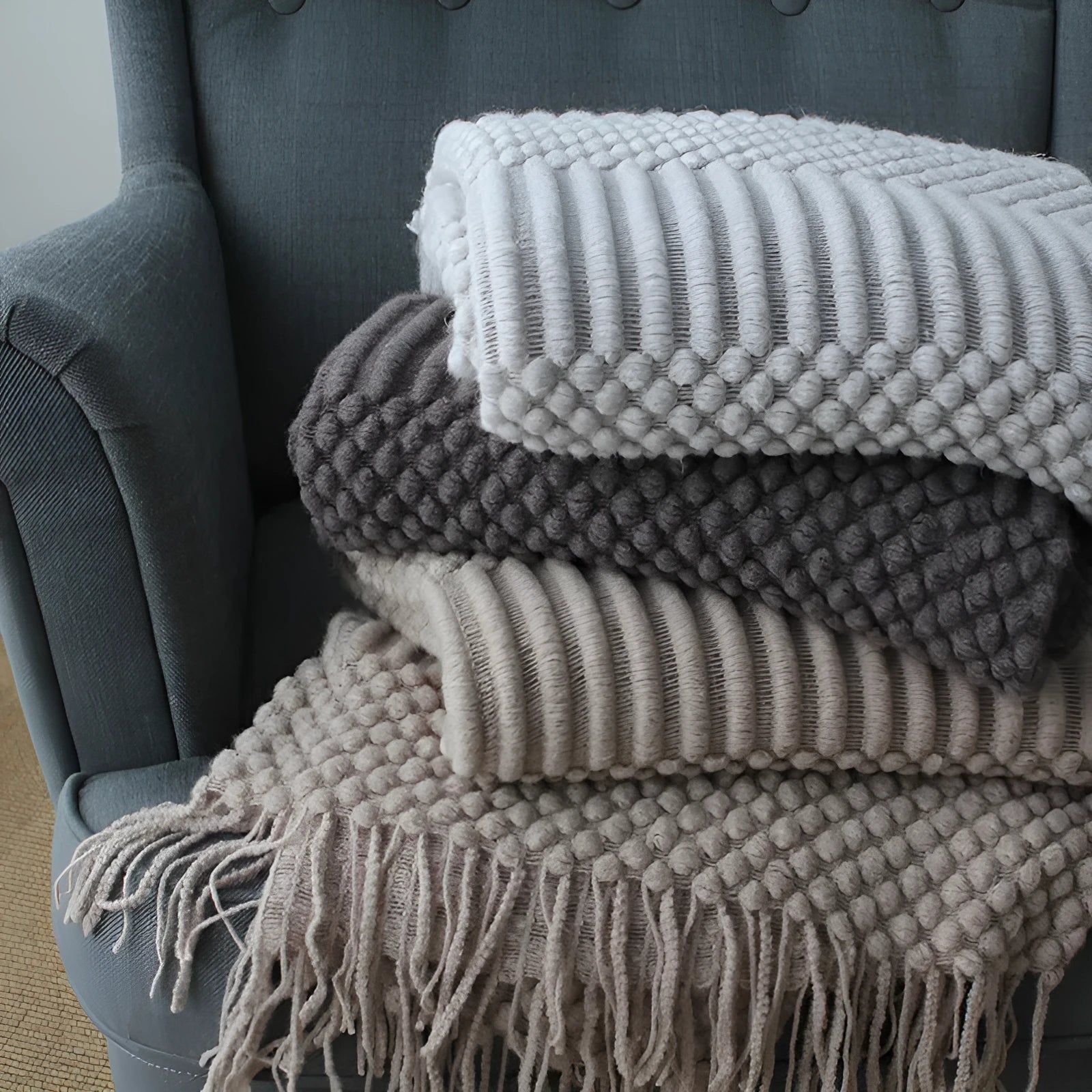 Small grey polyester nap blanket folded to show its texture and size.
