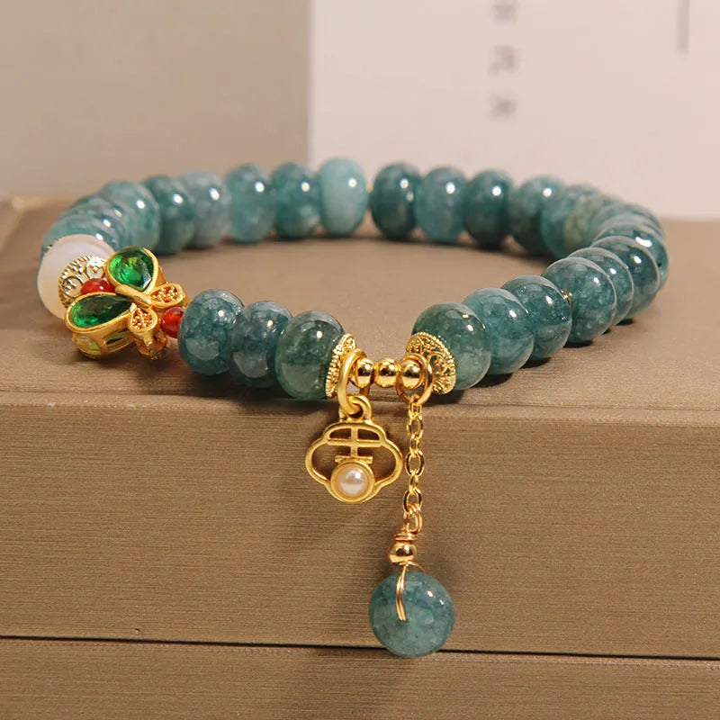 Women's blue water jade abacus bead crystal bracelet with butterfly charm and white agate accents