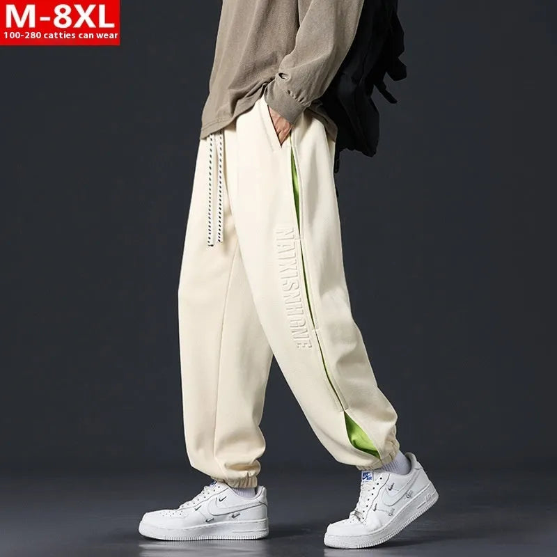 Men's ankle banded trousers in micro-elastic cotton with collage stitching, showing skinny leg and mid-waist fit.