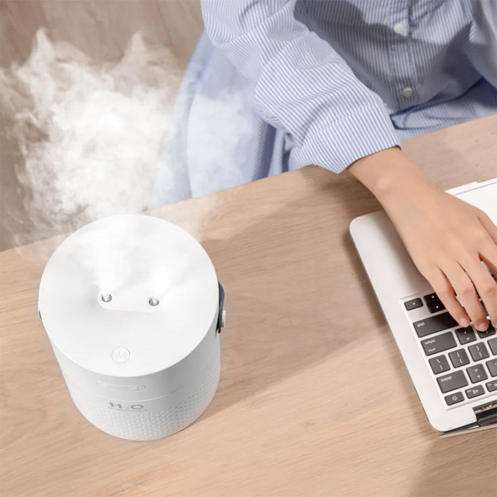 Slim green USB-rechargeable bedroom humidifier with dual mist nozzles and LED light on a wooden surface.