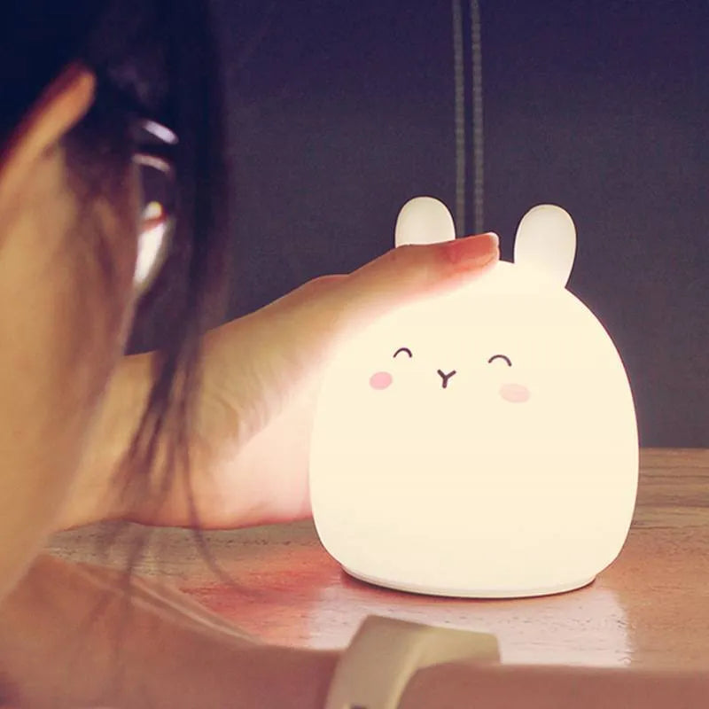 Silicone cute rabbit-shaped rechargeable night light showing colour change options and compact size.