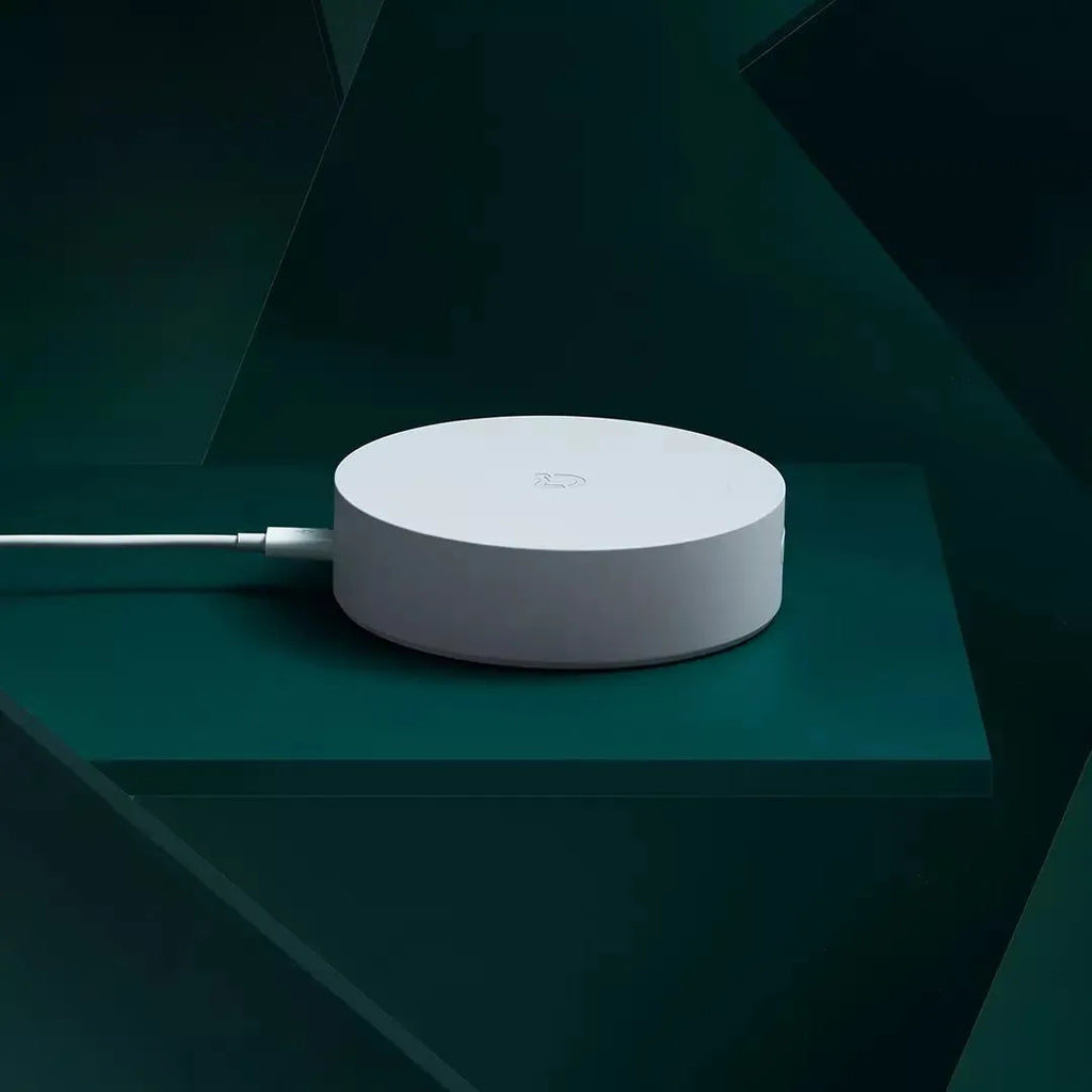 White circular smart home gateway with UK plug for wireless device control