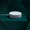 White circular smart home gateway with UK plug for wireless device control
