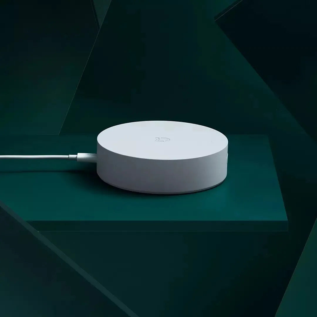 White circular smart home gateway with UK plug for wireless device control