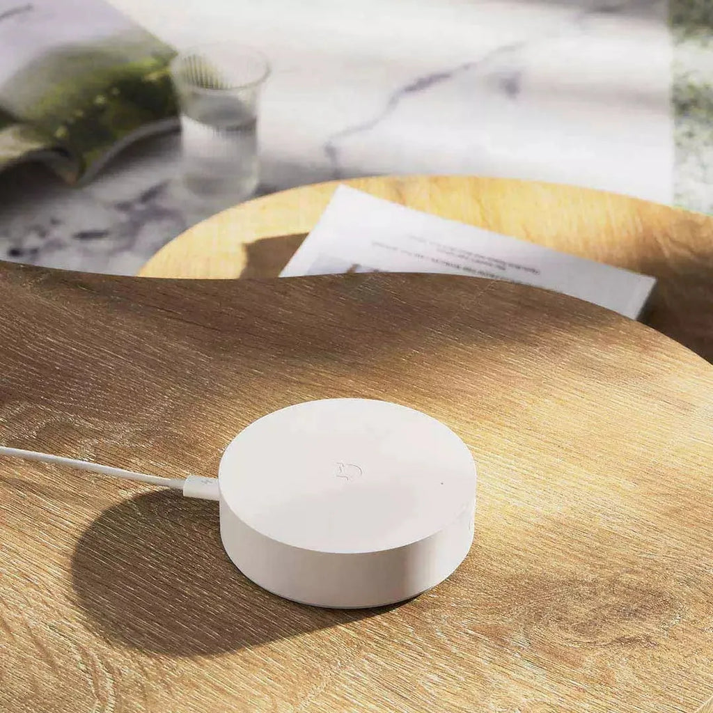 White circular smart home gateway with UK plug for wireless device control