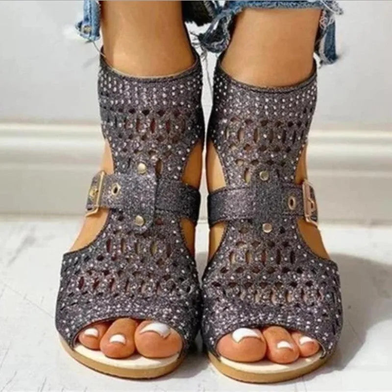 Women's beige rivet flat sandals with back zipper, low wedge heel, and fish mouth toe shape on a light background.