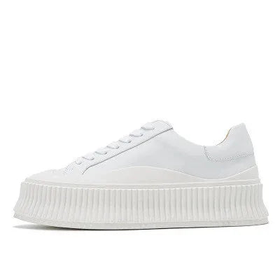 Women's mid-top platform sneakers with suede upper, thick sole, and lace-up design in black and white colours.