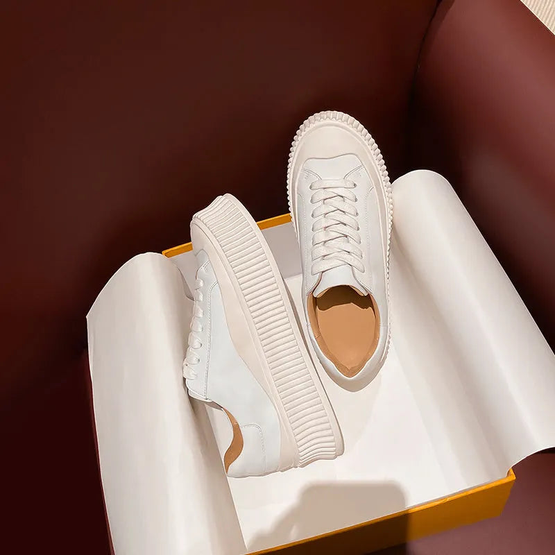 Women's mid-top platform sneakers with suede upper, thick sole, and lace-up design in black and white colours.