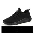 Men's black and white mesh sneakers with round toe design and lace-up closure on neutral background