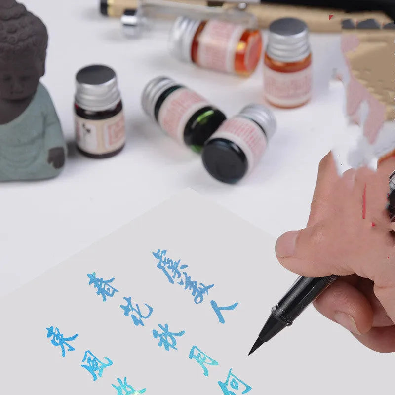 Set of six small high white glass bottles of gold powder antiquing ink for calligraphy in assorted colours