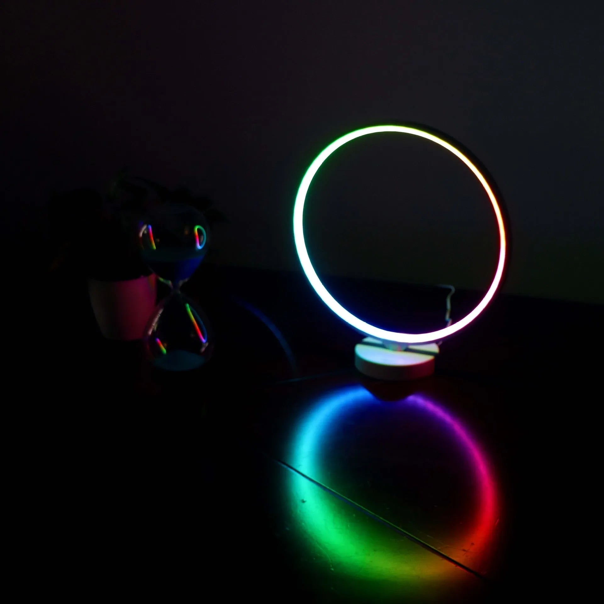 White Full Moon shaped table lamp with remote control on a wooden surface.