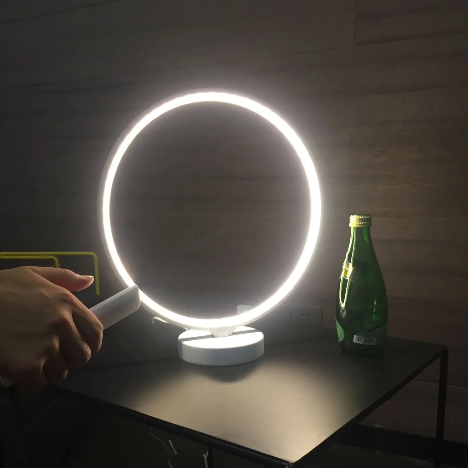 White Full Moon shaped table lamp with remote control on a wooden surface.