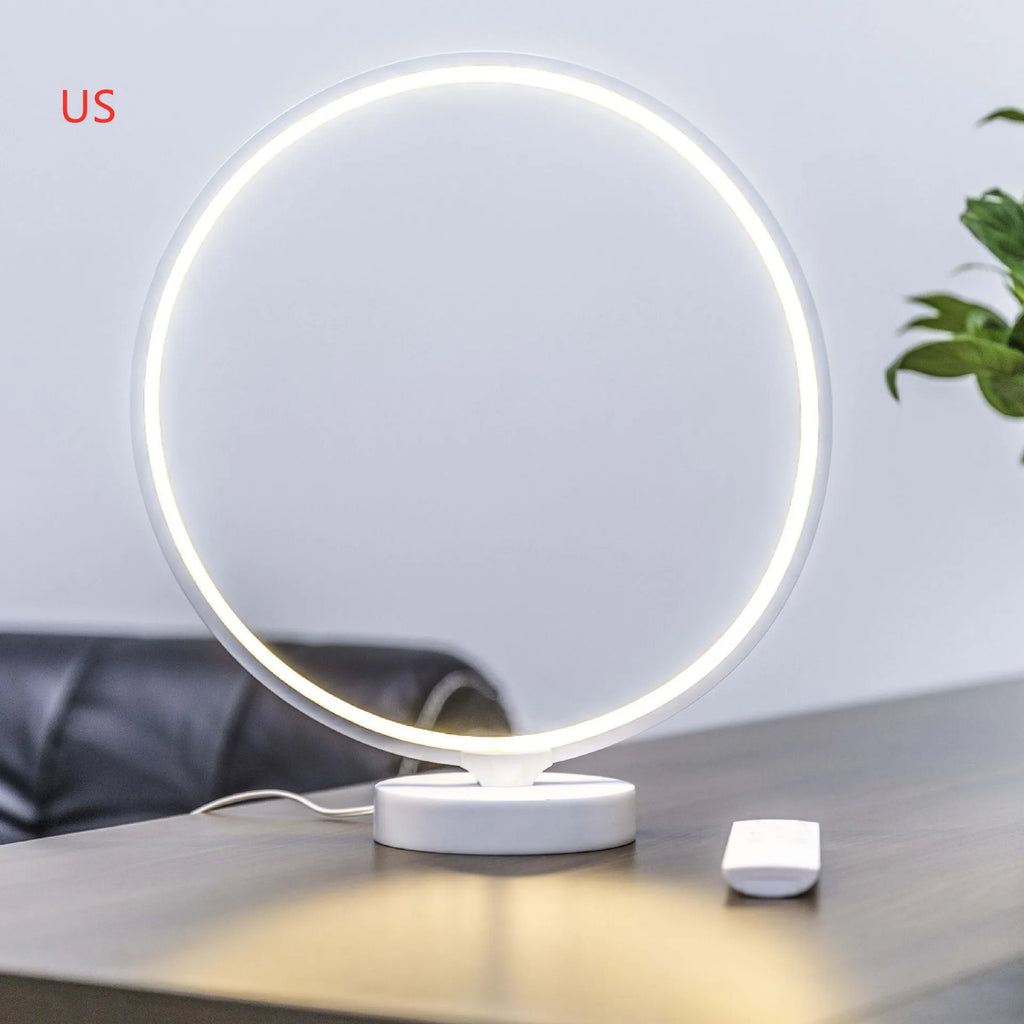 White Full Moon shaped table lamp with remote control on a wooden surface.