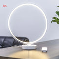 White Full Moon shaped table lamp with remote control on a wooden surface.