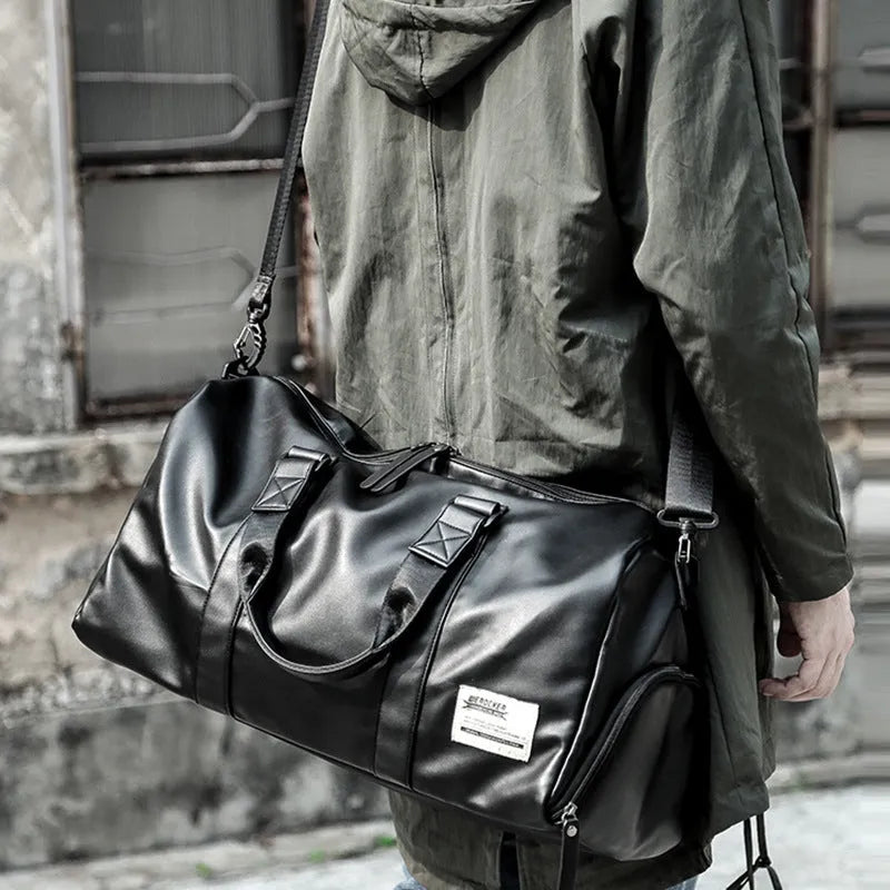 Large black PU leather sports training bag with multiple internal pockets, showing zipper opening and carry handle.