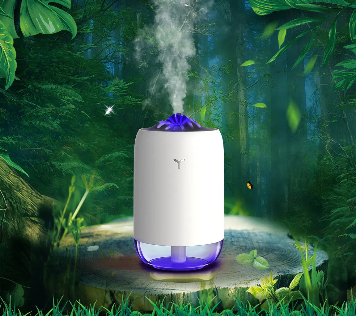White columnar magic flame humidifier and aroma diffuser on a desktop with mist and coloured light effect.