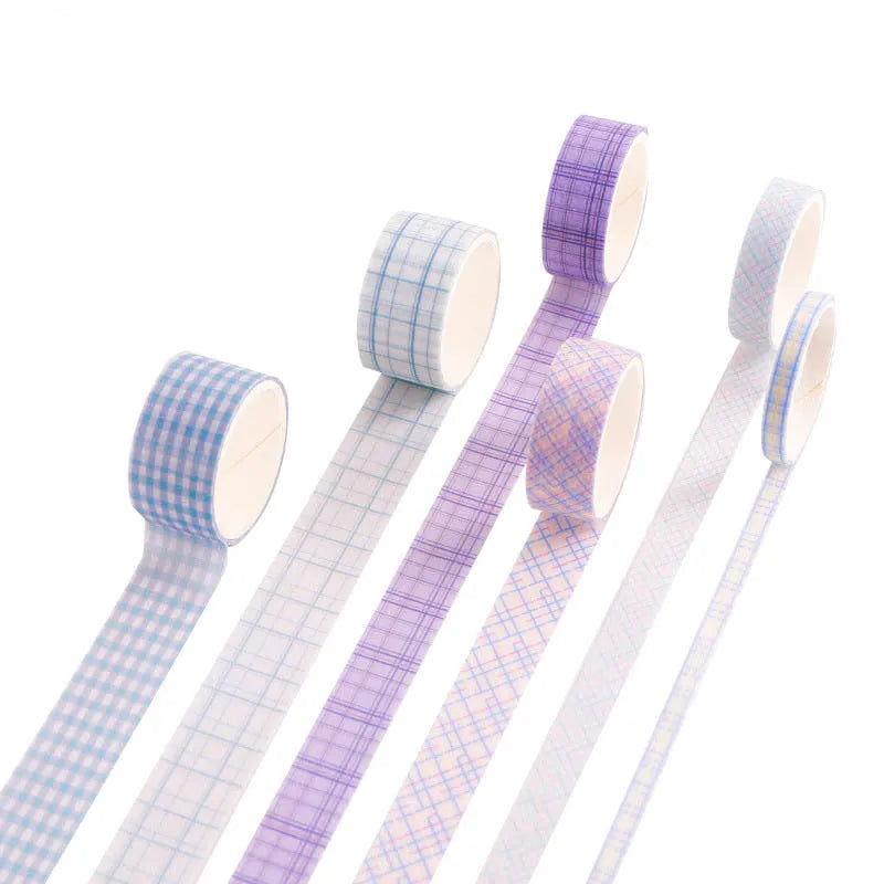Set of six rolls of retro plaid and floral Japanese washi tape in four different widths on a craft table.