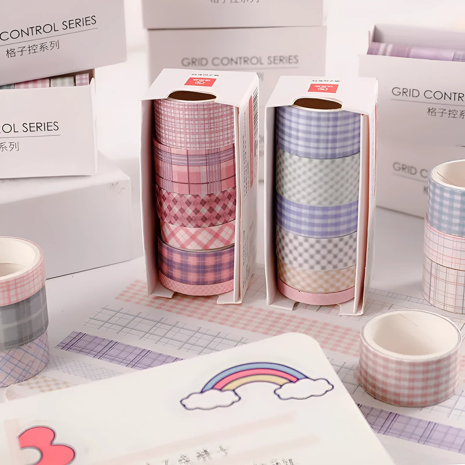 Set of six rolls of retro plaid and floral Japanese washi tape in four different widths on a craft table.