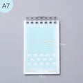 A7 hard cover detachable coil notebook showing multiple loose-leaf paper styles including timeline and checkered sheets