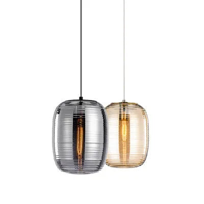 Simple modern glass table lamp on a table, shown in cognac and smoky grey colour options.