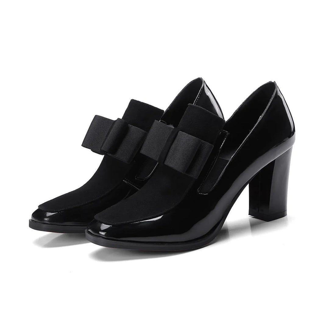 Women's black patent leather high heels with 8cm thick heel and square toe design on wooden floor