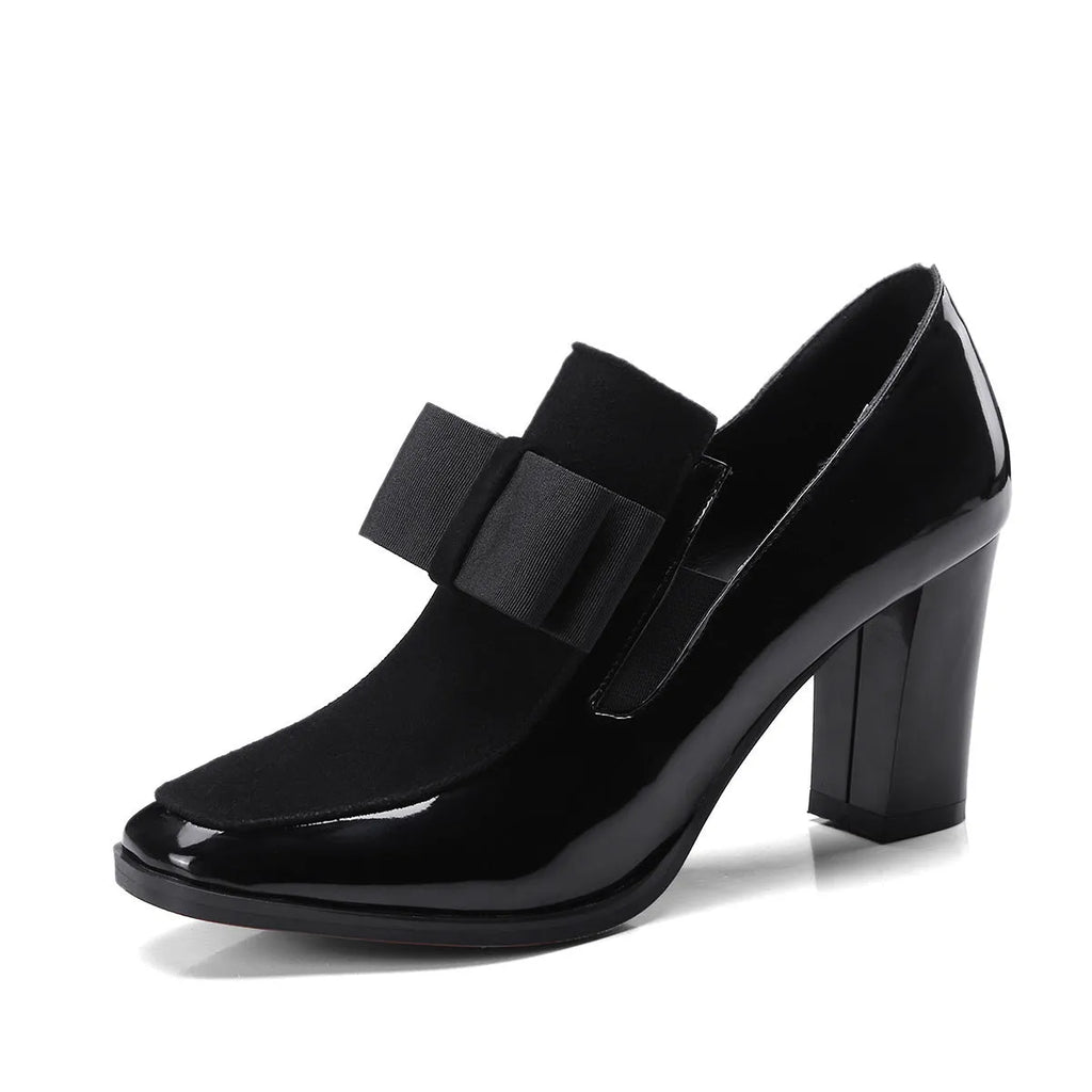 Women's black patent leather high heels with 8cm thick heel and square toe design on wooden floor