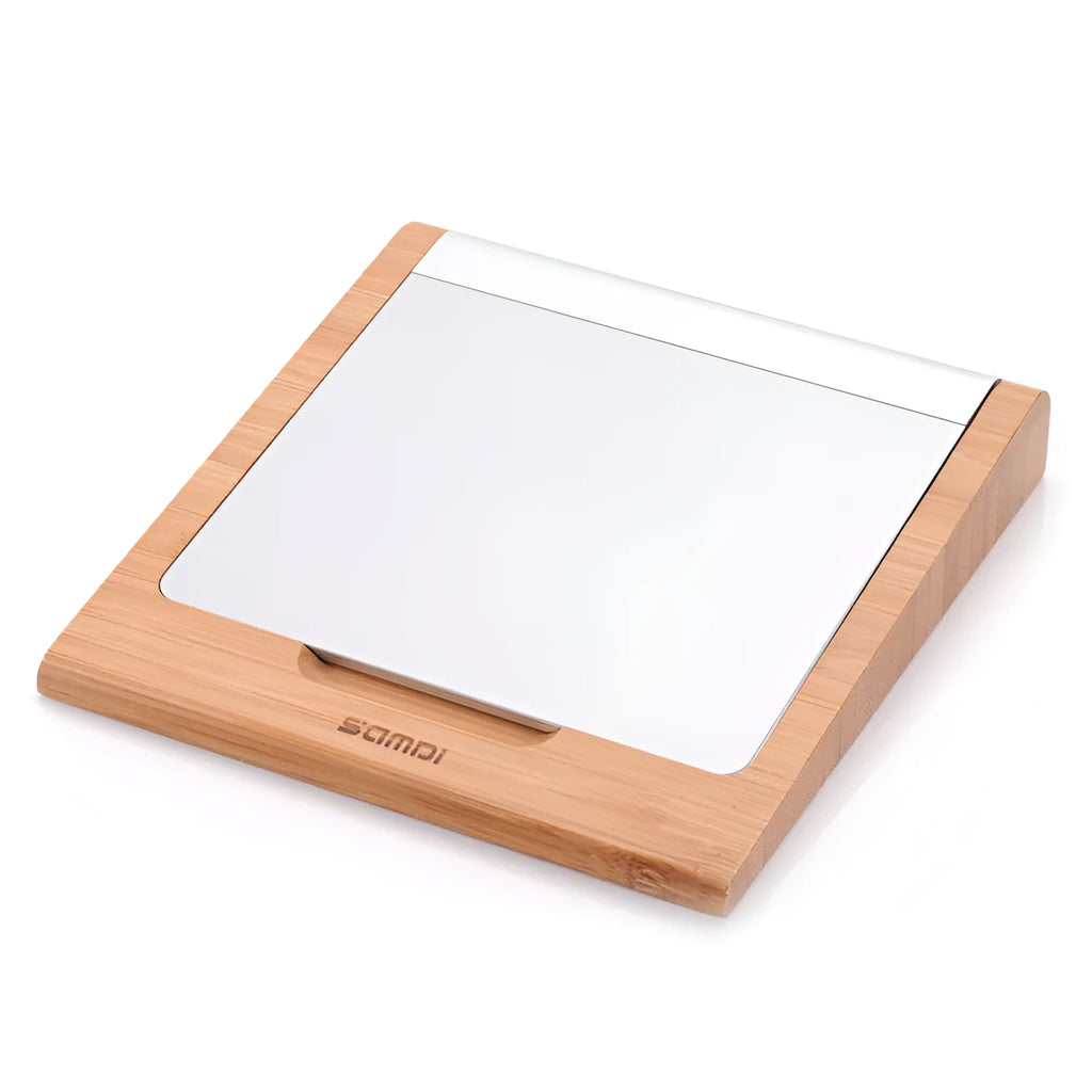 Bamboo wood Apple Bluetooth tablet bracket on a desk next to a trackpad.