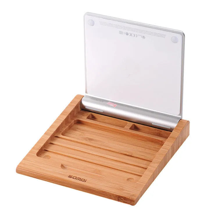 Bamboo wood Apple Bluetooth tablet bracket on a desk next to a trackpad.