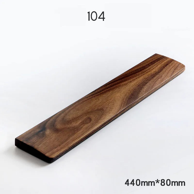 Solid walnut wood keyboard wrist rest with natural grain on a desk