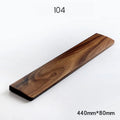 Solid walnut wood keyboard wrist rest with natural grain on a desk