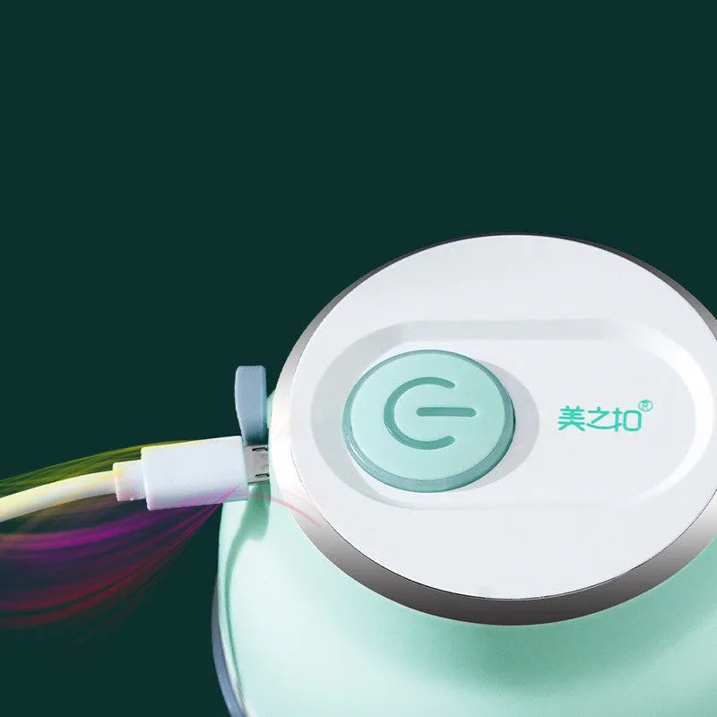 Portable electric mini food chopper with transparent cup and stainless steel blade on a kitchen counter