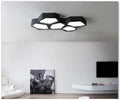 Geometric shaped LED light in black or white, measuring 380x260x80mm, with remote control for dimming