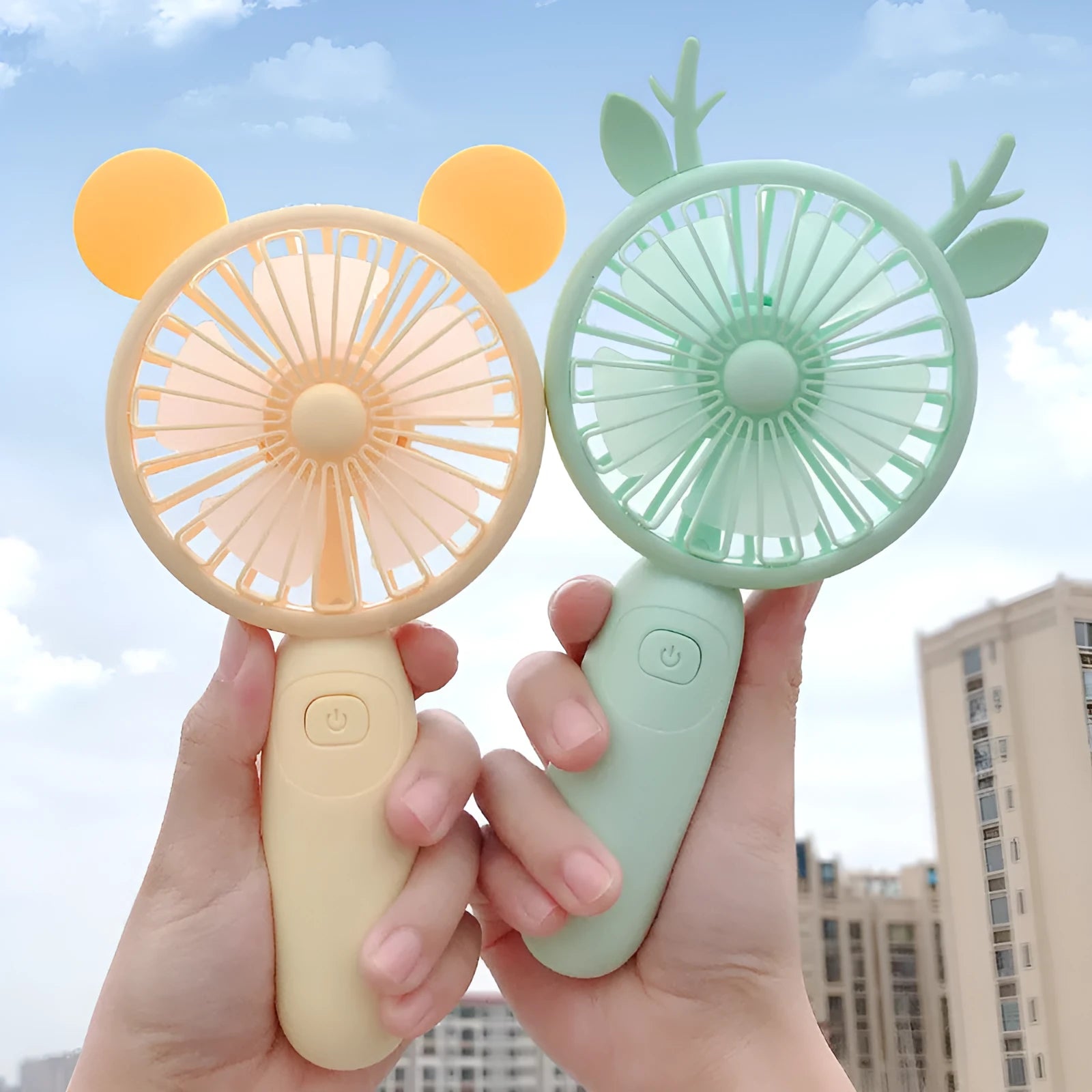 A cartoon-style handheld personal fan with plastic blades, shown in blue, green, pink, and yellow colour options.