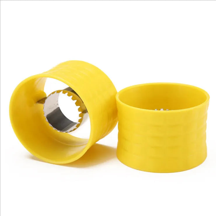 Yellow manual corn grinder thresher with corn-shaped PP handle on a kitchen worktop.