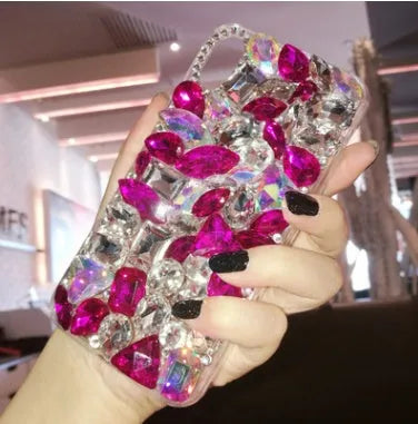 Clear rhinestone crystal decorative phone case for iPhone on a table.