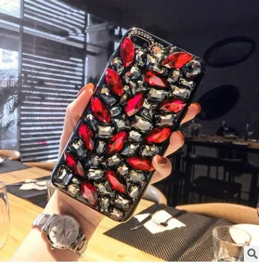 Clear rhinestone crystal decorative phone case for iPhone on a table.
