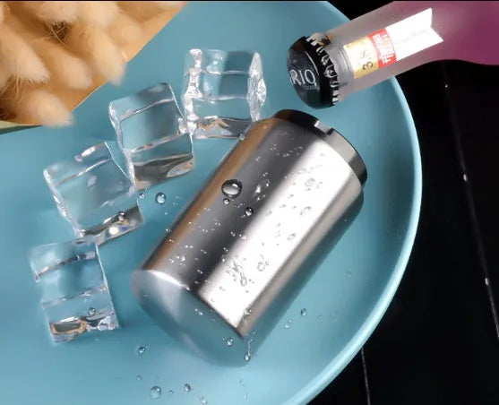 Stainless steel automatic beer bottle opener in assorted colours on a wooden surface.