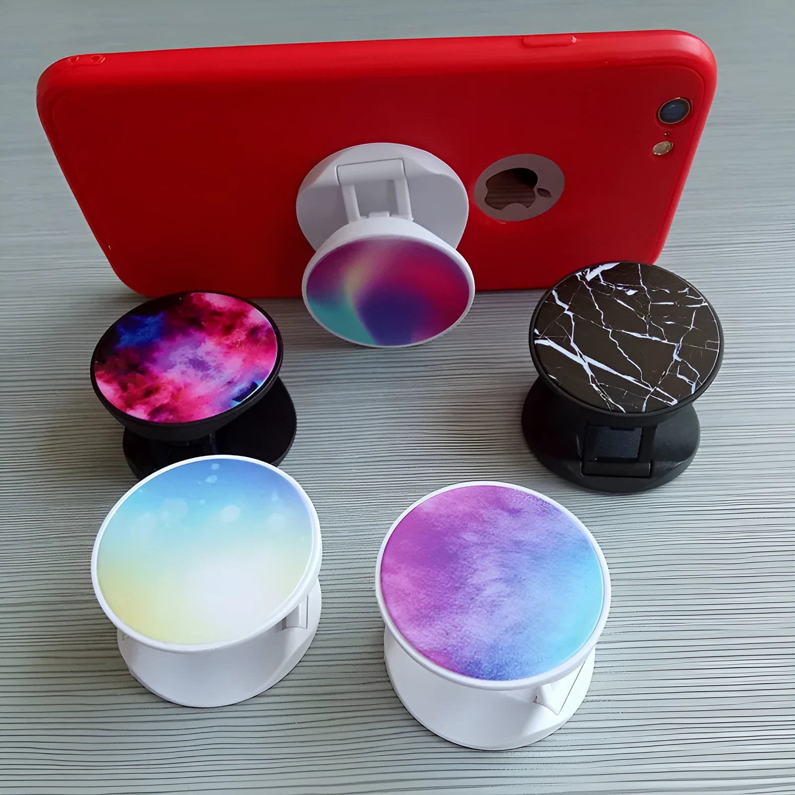 Universal folding mobile phone holder in a choice of colours on a desktop.