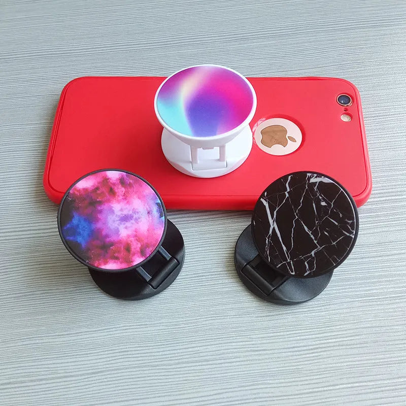 Universal folding mobile phone holder in a choice of colours on a desktop.