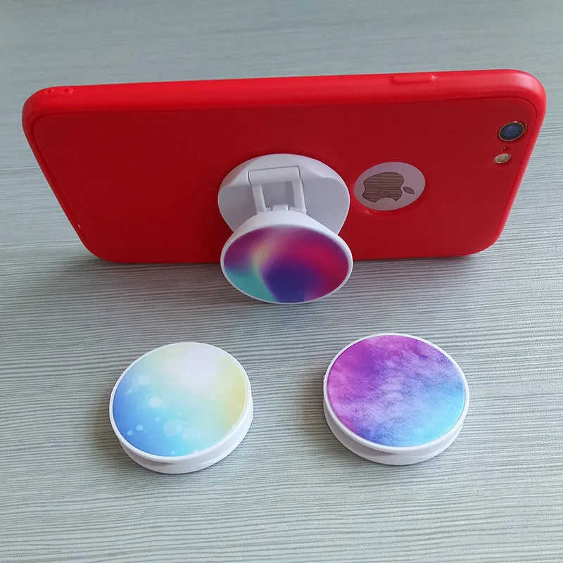 Universal folding mobile phone holder in a choice of colours on a desktop.