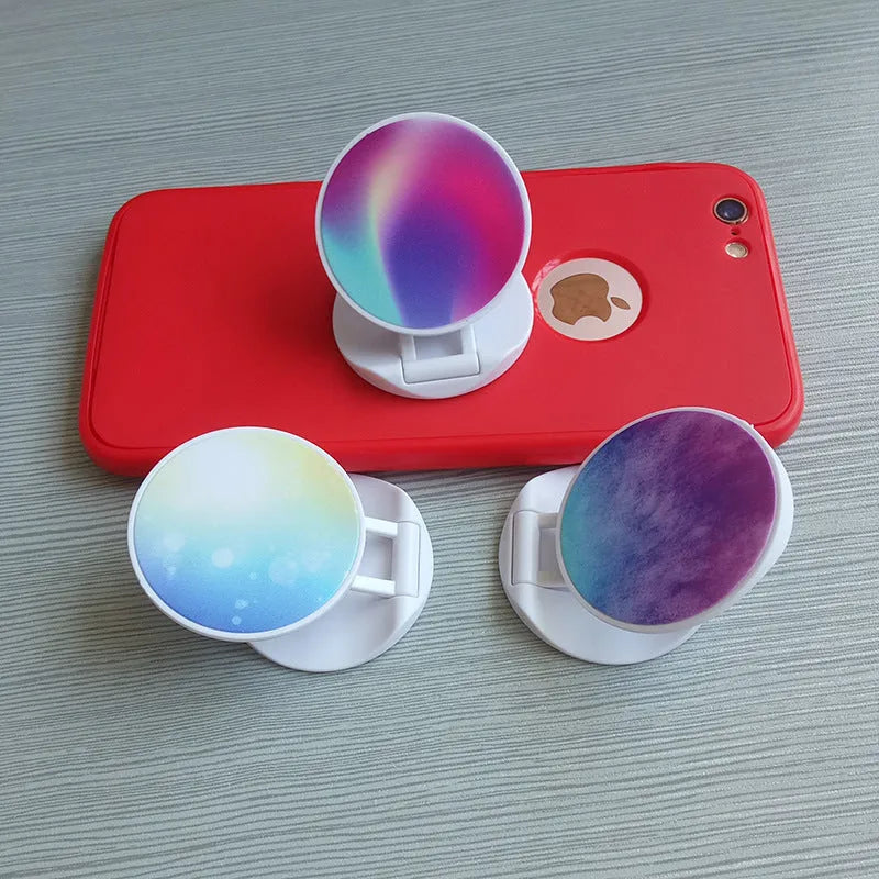 Universal folding mobile phone holder in a choice of colours on a desktop.