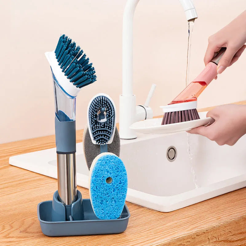 Long handled kitchen cleaning brush with a soap dispenser button and a stainless steel scouring block.