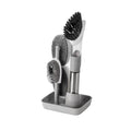 Long handled kitchen cleaning brush with a soap dispenser button and a stainless steel scouring block.